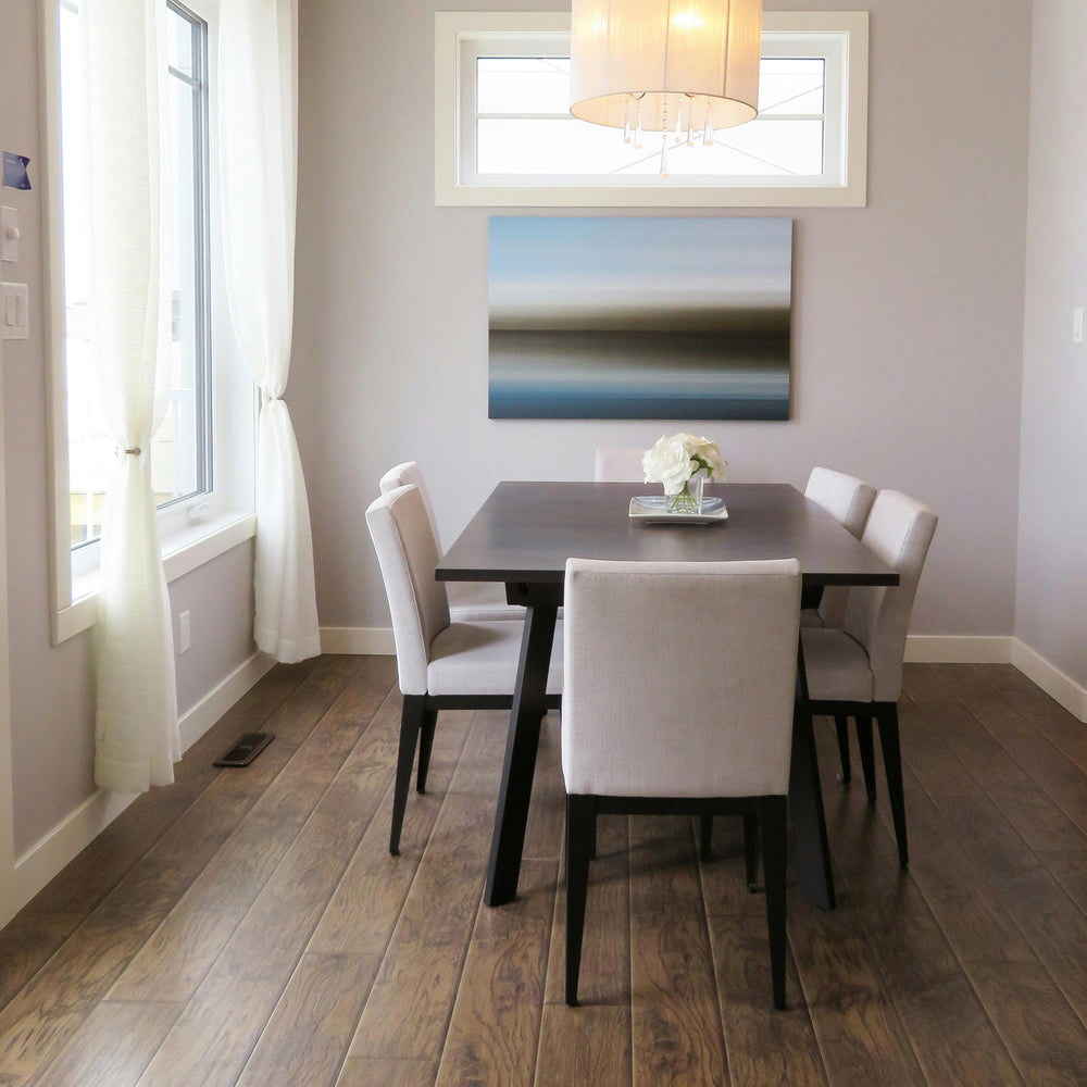 Modern white upholstered dining chairs with black legs around a dark wood table
